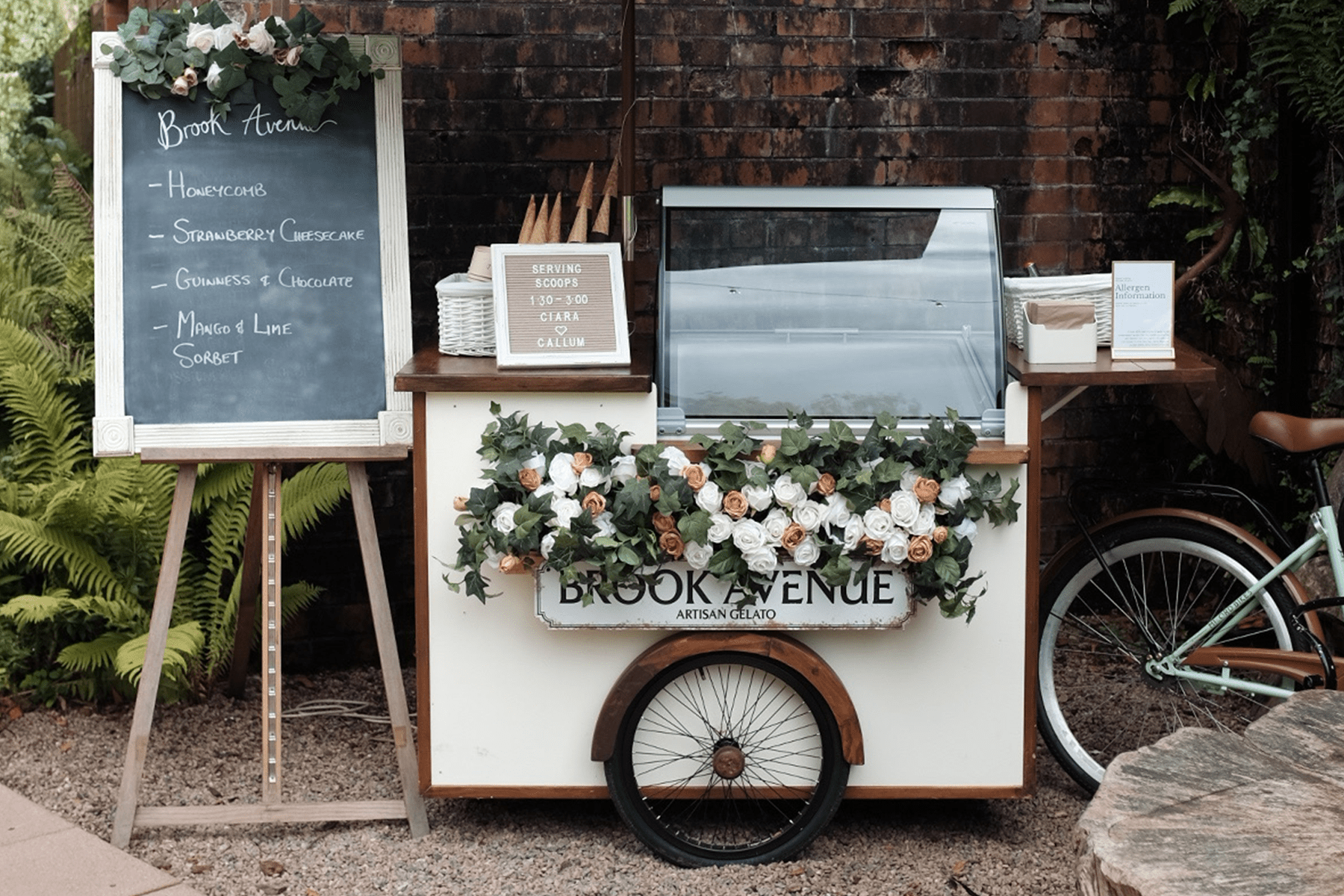 Ice cream/Gelato Bicycle Cart at Galgorm Ballymena Northern Ireland. Mint green bicycle with floral wedding basket and cart setup infront of Phantom house at Galgorm wedding venue.